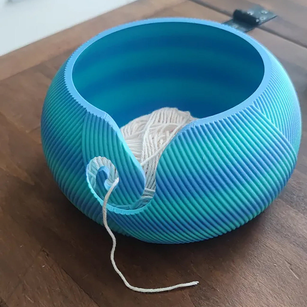 Yarn bowl with swirl cutout for knitting and crochet, holding a ball of yarn, view 6