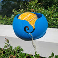 a blue and yellow object sitting on top of a white fence